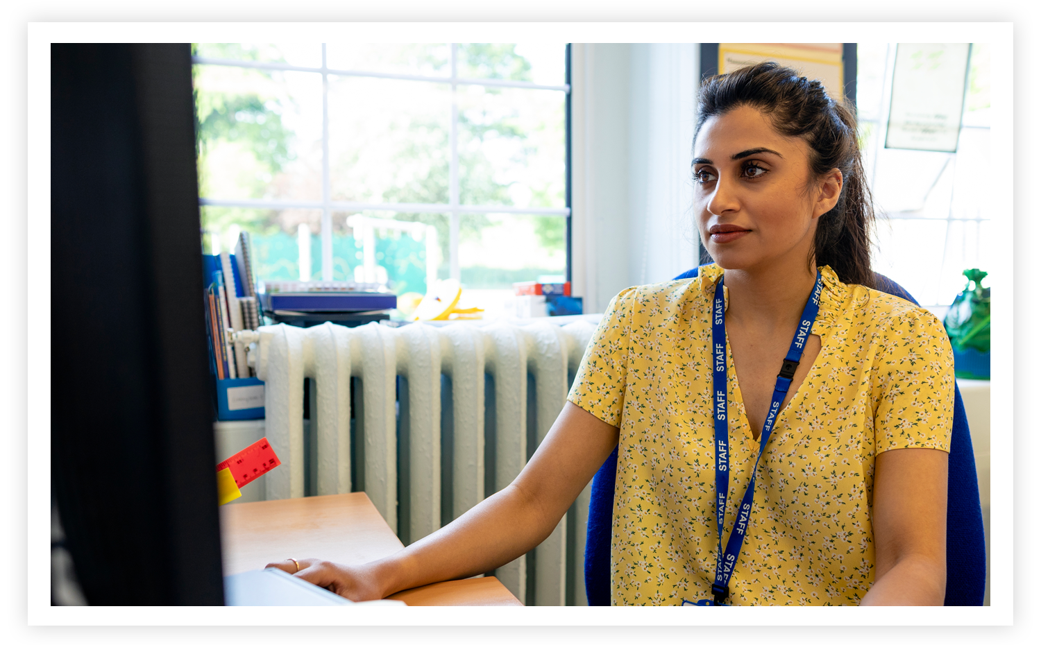 stock image of a teacher working at a computer